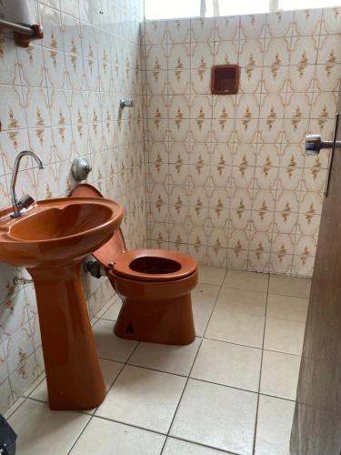 a bathroom with a toilet and a sink at Quarto Econômico no Centro para 2 Pessoas in Sete Lagoas