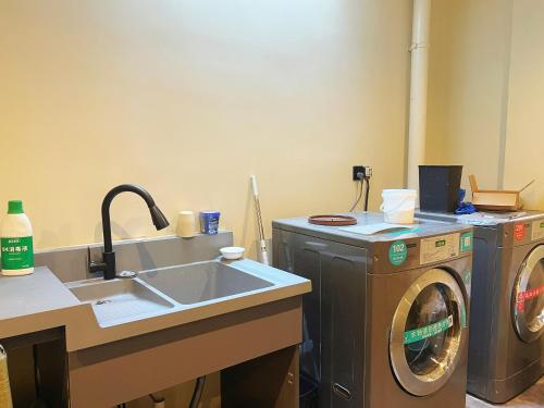 a laundry room with a sink and a washing machine at The Lake View Deyishe Resort in Thousand Island Lake in Thousand Island Lake