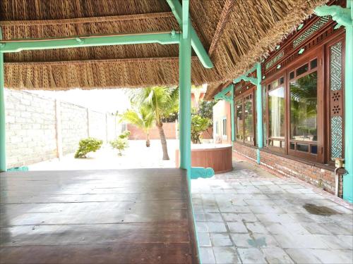 a pavilion with a bench in front of a building at Full Moon Village Resort in Mui Ne