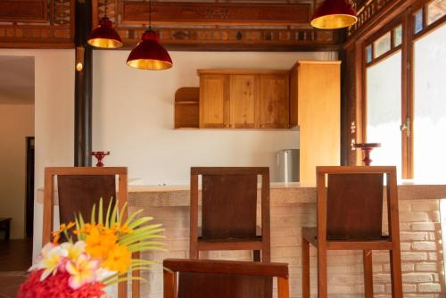 a kitchen with two chairs and a table with flowers at Full Moon Village Resort in Mui Ne