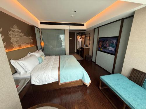 a bedroom with a bed and a tv in it at Till Bright Hotel, Foshan Shunde Ronggui Station Branch in Shunde