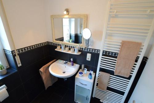 un baño con lavabo y espejo en Greta, en Norddeich
