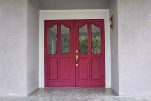 a red door in a white building with at Massive Cherry Garden Home in Cherry Garden