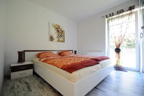 Un dormitorio con una cama y una ventana grande. en Taddel, en Norddeich