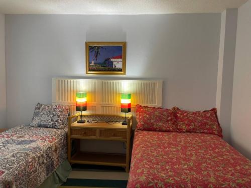 a room with two beds and a table with two lamps at Massive Cherry Garden Home in Cherry Garden