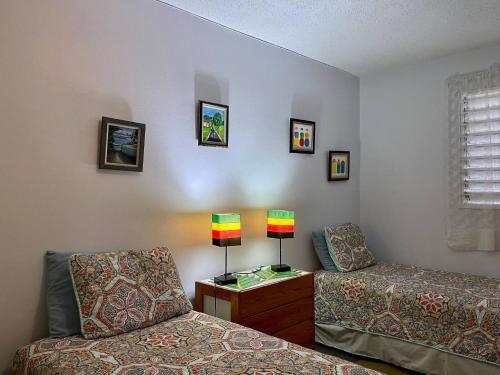 a room with two beds and a table with a lamp at Massive Cherry Garden Home in Cherry Garden