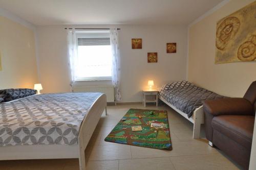 - une petite chambre avec 2 lits et un canapé dans l'établissement Feldblick-im-Landhaus-Haan, à Norden