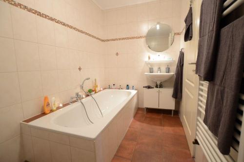 une salle de bain blanche avec une baignoire et un lavabo dans l'établissement Deichjuwel-im-Landhaus-Haan, à Norddeich