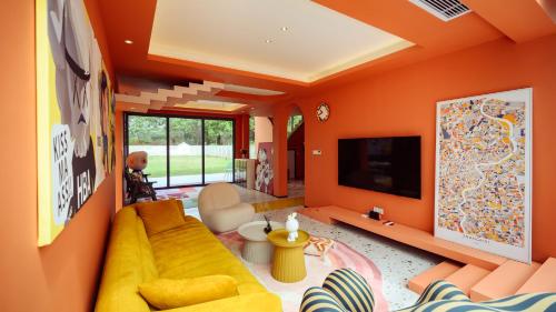 a living room with orange walls and a yellow couch at Mr. Gao and Ms. Feng's original homestay in Waxie