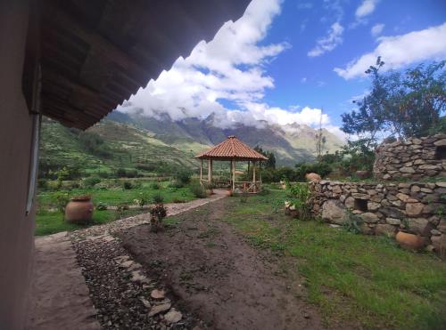 a gazebo in a field with mountains in the background at Bearded Moutaineer sacred garden & lodge in San Salvador
