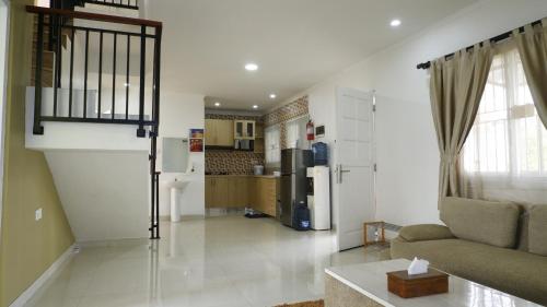 a living room with a couch and a kitchen at Diyar Villas Puncak K3/2A in Puncak