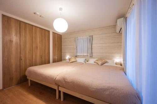 a bedroom with a large bed in a room at Hotel Tsunagari in Fukuoka