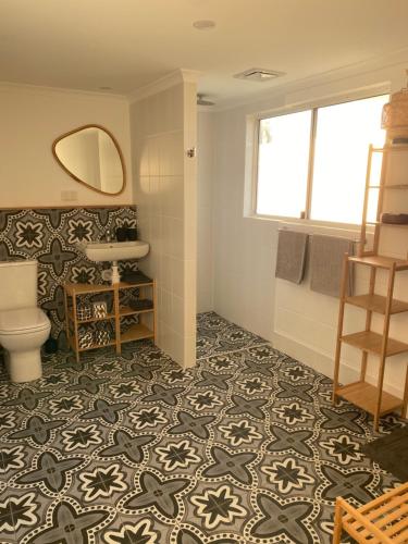 a bathroom with a toilet and a sink and a mirror at Sea Dragon in Agnes Water