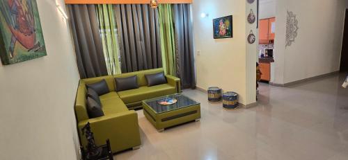 a living room with a green couch and a table at BL Homestay & Suite in Agra