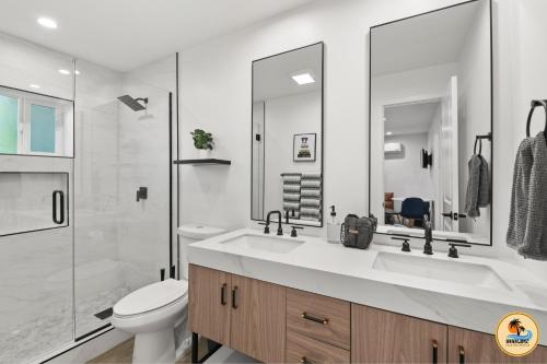Un baño blanco con inodoro y lavabo. en Huge 7BR Estate with Pool, Guest House and Game Room, en San Diego