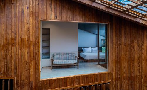 a room with a window with a bed and a chair at Harvest Day Hoi An in Hoi An