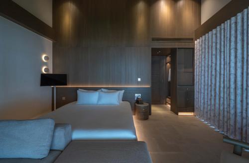 a hotel room with a bed and a couch at Harvest Day Hoi An in Hoi An