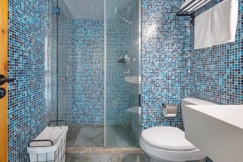 a blue tiled bathroom with a toilet and a shower at Floral Moganshan Natural Residence Pet Resort B&B in Huzhou