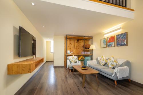a living room with a couch and a tv at Floral Moganshan Natural Residence Pet Resort B&B in Huzhou