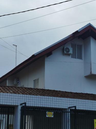 a white building with a window and a fan at Sobrado em Caiobá in Matinhos