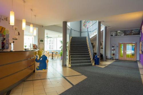 a lobby of a store with a staircase and a restaurant at Familienhotel Citylight in Berlin