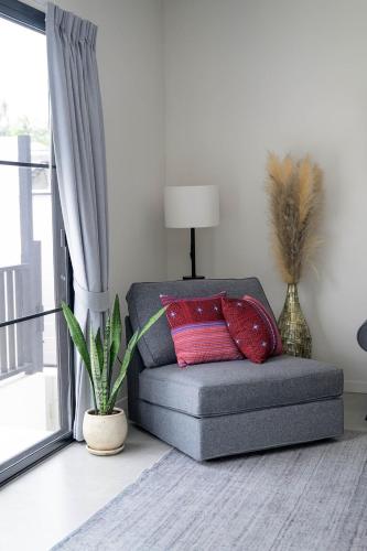 a couch with two red pillows in a living room at Coconut Breeze Villa #1 in Haad Chao Phao
