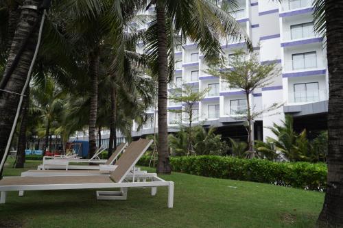 deux chaises longues sur une pelouse devant un bâtiment dans l'établissement Havana Home at Arena Cam Ranh, à Cam Ranh International Airport