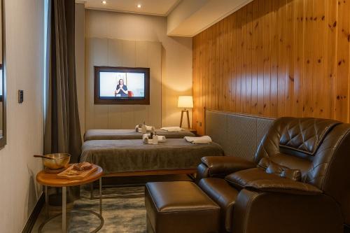 una habitación de hotel con una cama y una silla en Le Charmé Suites - Subic, en Olóngapo