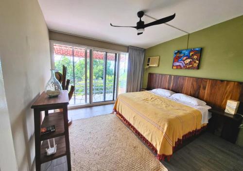 プエルト・エスコンディードにあるCasa Cactus - Amplia Casa de 2-Habitaciones con Jardín y Albercaのベッドと天井扇風機のある寝室