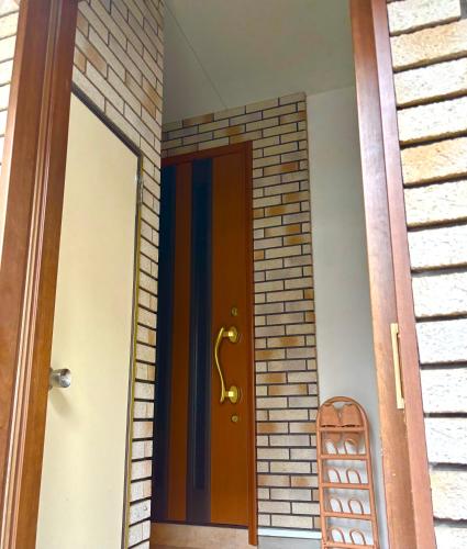 a door to a house with a brick wall at 覚羅中央区別荘202室 in Chiba