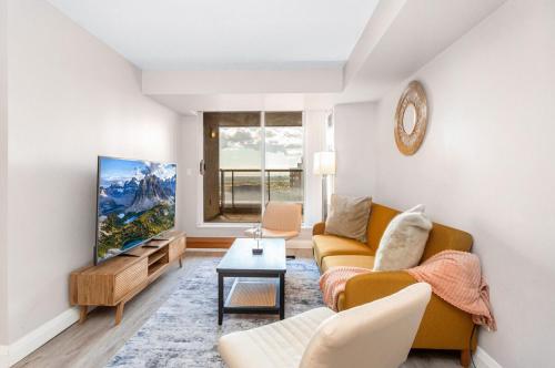 a living room with a couch and a tv at SkyView 2BR Plus Den Stunning Views Steps to SQ1 Mall in Mississauga