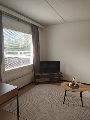 a living room with a television and a coffee table at Kotoisa yksiö lähellä palveluita in Sonkajärvi