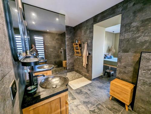 une salle de bains avec deux lavabos et un grand miroir dans l'établissement La villa Blue Banian, à Saint-Pierre