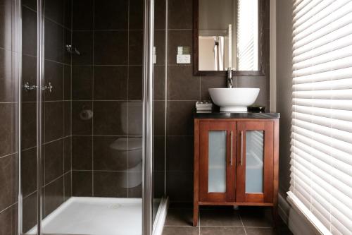 W łazience znajduje się prysznic i umywalka. w obiekcie Oscars Hotel and Cafe Bar w mieście Ballarat