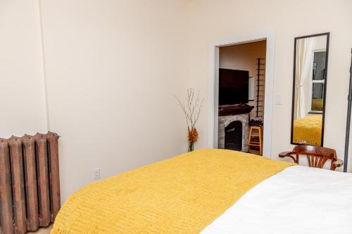 a bedroom with a bed with a yellow blanket at B Hotel in Toronto