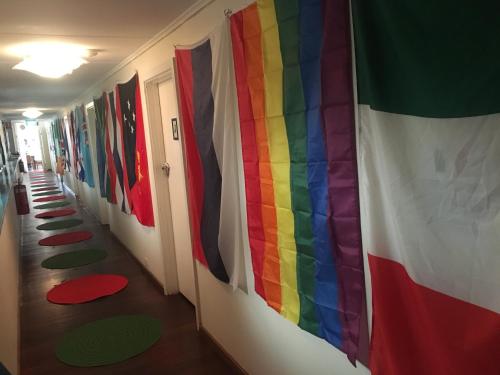 a hallway with a rainbow flag and a row of flags at 1849 Backpackers Albany in Albany