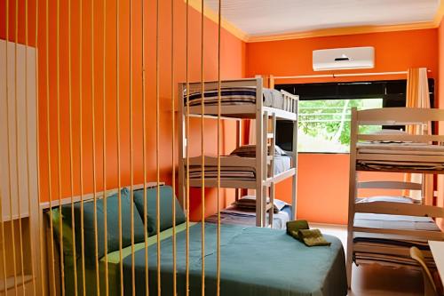 a room with bunk beds in a room with orange walls at Vila Jaú Coliving Apartamentos e Studios - Djalma Batista in Manaus