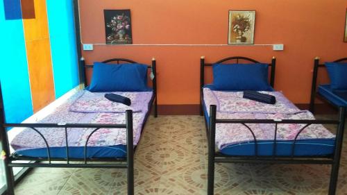 two beds in a room with blue and orange walls at Blue Hostel in Haad Rin