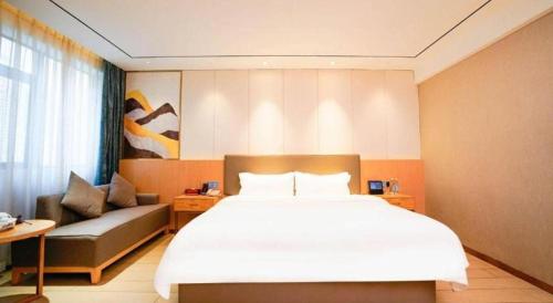 a bedroom with a large bed and a couch at Quanzhou Binhai Hotel in Quanzhou