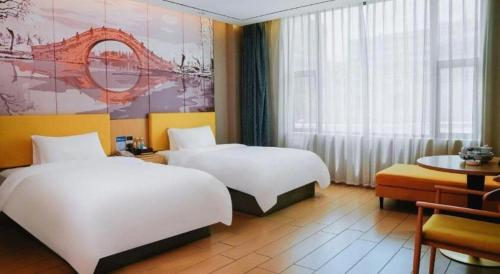 a hotel room with two beds and a table at Quanzhou Binhai Hotel in Quanzhou