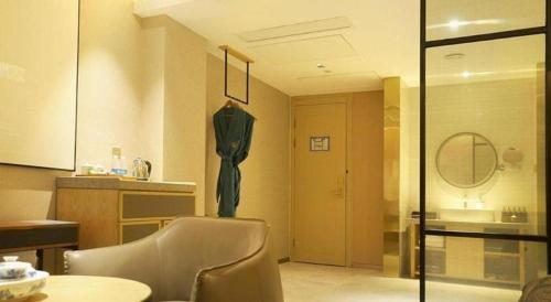 a room with a table and a chair and a mirror at Quanzhou Binhai Hotel in Quanzhou