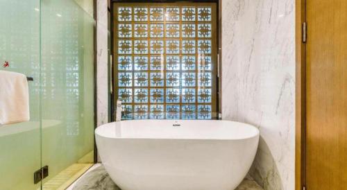 a white bath tub in a bathroom with a window at Harbin Splendent Hotel in Harbin