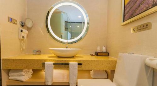 a bathroom with a sink and a mirror at Lavande Hotel Yichang Railway East Station Branch in Yichang