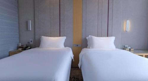 two beds sitting next to each other in a room at Lavande Hotel Yichang Railway East Station Branch in Yichang