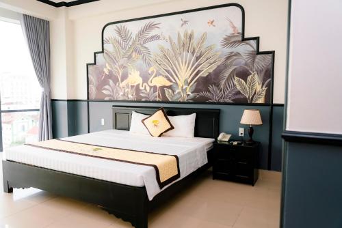 a bedroom with a bed with a large painting on the wall at Khách sạn Đại An Ninh Bình in Ninh Binh