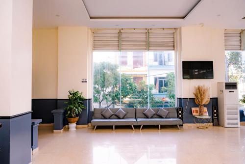a living room with a couch and a large window at Khách sạn Đại An Ninh Bình in Ninh Binh