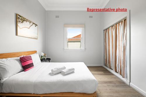 a bedroom with a bed with two towels on it at Affordable Double Bedroom - Heart of Belmore with Shared Bathroom in Sydney