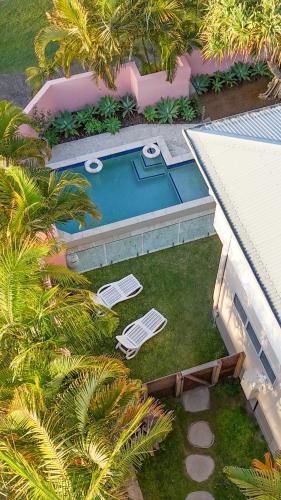 an overhead view of a swimming pool with two lawn chairs at Aloha Byron Bay in Byron Bay