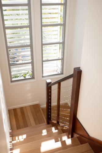 a staircase with two windows in a room at Aloha Byron Bay in Byron Bay