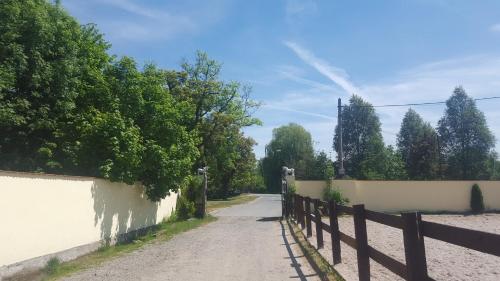 a dirt road with a fence on the side at Farm Stay NH Stables in Nýřany